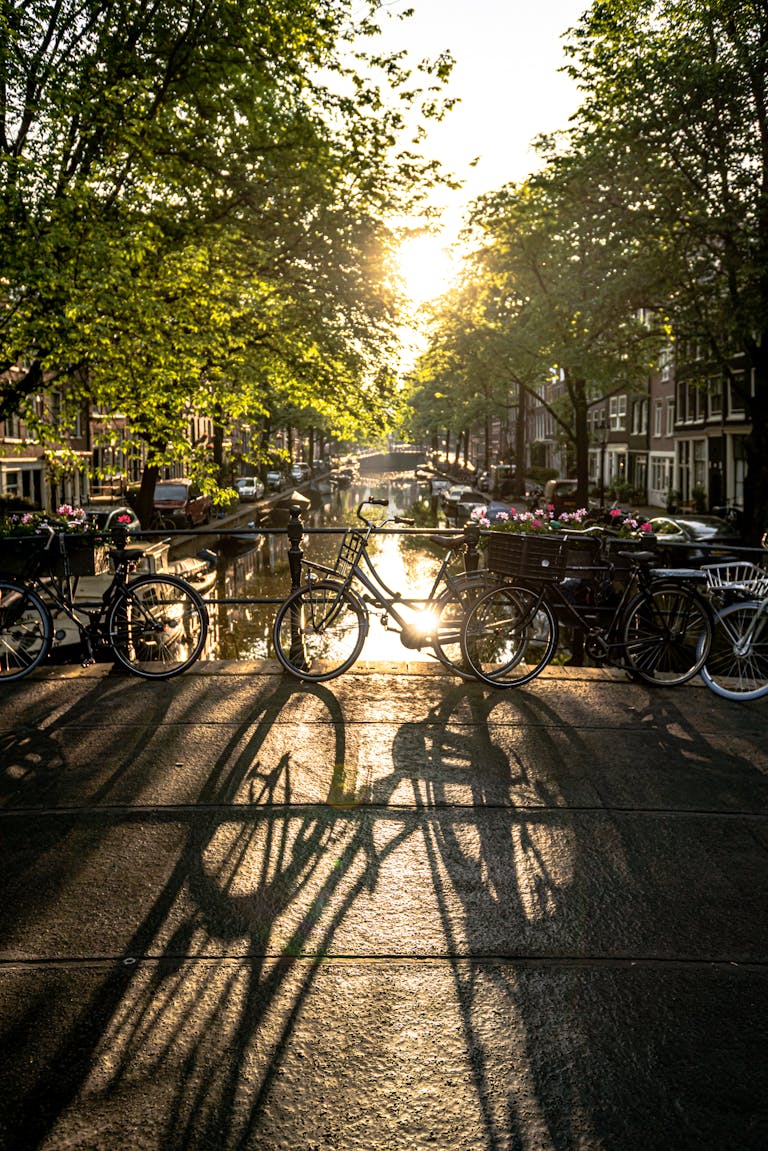 Typisches Amsterdam-Motiv – Fahrrad auf Brücke mit Blick auf Gracht und Boote im Sonnenlicht