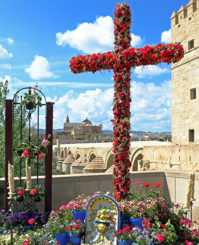 Blumenkreuz bei den Cruces de Mayo in Córdoba mit Blick auf Mezquita und römische Brücke – ein Highlight im Pfingsten Urlaub in Andalusien